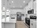Modern kitchen with white cabinets, stainless steel appliances, and pendant lighting over the island at 16097 Old Fox Trl, Port Charlotte, FL 33953