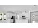 Bright, modern kitchen with white cabinetry, stainless steel appliances, and a view of the front entrance at 16097 Old Fox Trl, Port Charlotte, FL 33953