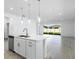 Bright kitchen with quartz countertops, stainless steel appliances, and an open layout to the dining area at 16097 Old Fox Trl, Port Charlotte, FL 33953