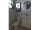 Stylish bathroom features modern fixtures, a round LED mirror, and trendy artwork at 1750 Gold Ave, Sarasota, FL 34235