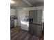 Bright kitchen with stainless steel appliances, white cabinets, and wood grain vinyl flooring at 1750 Gold Ave, Sarasota, FL 34235