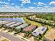 Aerial view of homes with lush landscaping, surrounded by serene lakes, greenery, and clear blue skies at 17714 Northwood Pl, Bradenton, FL 34202