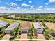 Aerial view of homes with red-tiled roofs and brick driveways, surrounded by green landscaping and trees at 17714 Northwood Pl, Bradenton, FL 34202