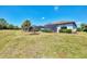 Lush backyard with manicured lawn, garden beds, and screened-in lanai at 17714 Northwood Pl, Bradenton, FL 34202