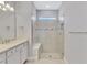 Bathroom featuring a single vanity with white cabinets and a glass-enclosed shower with gray and silver tile at 17714 Northwood Pl, Bradenton, FL 34202