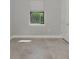 Minimalist bedroom showcasing a window with a view, neutral walls, and tile floor at 17714 Northwood Pl, Bradenton, FL 34202
