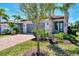 Attractive home featuring a red brick driveway, gray garage door, and well-manicured landscaping with lush bushes at 17714 Northwood Pl, Bradenton, FL 34202