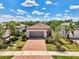 Beautiful home with a red brick driveway and tropical landscaping, including palm trees and lush green grass at 17714 Northwood Pl, Bradenton, FL 34202
