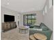 Bright living room featuring a comfortable green sectional sofa, stylish furniture, and views of the outdoors at 17714 Northwood Pl, Bradenton, FL 34202
