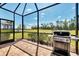 Screened-in brick lanai area with a Weber grill, offering a relaxing outdoor space at 17714 Northwood Pl, Bradenton, FL 34202