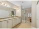 Bathroom featuring double sinks, granite countertops, and a glass-enclosed shower at 182 Bella Vista Ter # 23A, Nokomis, FL 34275