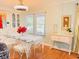 Bright dining room features a glass table with white chairs and built in cabinets at 1829 Cypress Point Ln, Sarasota, FL 34234