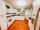 Bright kitchen with white cabinets, a white oven and hardwood floors at 1829 Cypress Point Ln, Sarasota, FL 34234