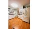Bright kitchen with white cabinets, a white refrigerator, and hardwood floors at 1829 Cypress Point Ln, Sarasota, FL 34234