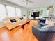 Bright living room with hardwood floors, ceiling fan, light green walls and large TV at 1829 Cypress Point Ln, Sarasota, FL 34234
