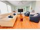 Light, bright living room with hardwood floors, ceiling fan, light green walls and large TV at 1829 Cypress Point Ln, Sarasota, FL 34234