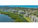 Aerial view of condos surrounded by lush greenery and waterways with ocean in the distance at 1932 Harbourside Dr # 217, Longboat Key, FL 34228