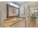 Stylish bathroom with granite counters, a decorative mirror, and view into dining area at 1932 Harbourside Dr # 217, Longboat Key, FL 34228