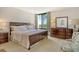 Bedroom with dark wooden furnishings, neutral walls, and large windows for natural light at 1932 Harbourside Dr # 217, Longboat Key, FL 34228