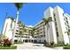 Beautiful building exterior with bright white facade, lush tropical landscaping, and paved driveway at 1932 Harbourside Dr # 217, Longboat Key, FL 34228