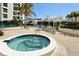 Relaxing pool area with spa, ample seating, lush palms, and the building close by at 1932 Harbourside Dr # 217, Longboat Key, FL 34228