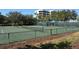 Well-maintained tennis courts surrounded by trees and lush greenery, close to the main building at 1932 Harbourside Dr # 217, Longboat Key, FL 34228