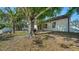 A serene backyard features a playset nestled around a mature tree providing shade and enjoyment at 2385 Tall Oak Ct, Sarasota, FL 34232