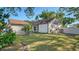 Charming home with manicured lawn, lush landscaping, and a decorative fence at 2385 Tall Oak Ct, Sarasota, FL 34232