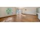 Sunny living area featuring hardwood floors, a unique arched window, and natural light at 2385 Tall Oak Ct, Sarasota, FL 34232