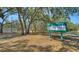 Welcoming park entrance sign for Colonial Oaks Park, surrounded by mature trees and lush greenery at 2385 Tall Oak Ct, Sarasota, FL 34232