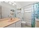Clean bathroom with shower and tub combo, peach vanity, a large mirror, and decor accents at 3390 Yonge Ave # 41, Sarasota, FL 34235