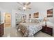 Bright bedroom with neutral colors, ceiling fan, mirrored closet, and two end tables with lamps at 3390 Yonge Ave # 41, Sarasota, FL 34235
