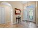 Inviting foyer with stone tile floors, a decorative mirror and double doors at 3390 Yonge Ave # 41, Sarasota, FL 34235