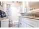 Clean bathroom with a shower, toilet and vanity with a granite countertop, well-lit mirror and storage at 3620 Ironwood Cir # 606, Bradenton, FL 34209