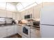 Well-lit kitchen featuring white cabinetry, granite countertops and modern appliances at 3620 Ironwood Cir # 606, Bradenton, FL 34209