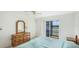 Bright bedroom featuring a dresser and a sliding glass door to a balcony with water views at 3763 Lake Bayshore Dr # 310, Bradenton, FL 34205