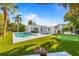 Spacious backyard featuring a sparkling pool, putting green, and inviting lounge area, creating an entertainer's paradise at 414 79Th St, Holmes Beach, FL 34217