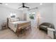 Bright bedroom with natural light, light hardwood floors, a ceiling fan, and stylish modern decor at 414 79Th St, Holmes Beach, FL 34217