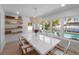 Bright dining room with view of pool features a modern table, stylish light fixture, and wood shelving at 414 79Th St, Holmes Beach, FL 34217