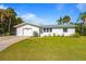 Charming single-story home featuring a lush front lawn, pristine white exterior, and a convenient attached garage at 414 79Th St, Holmes Beach, FL 34217