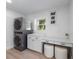 Well-equipped laundry room featuring modern washer and dryer, white cabinets, and a built-in desk area at 414 79Th St, Holmes Beach, FL 34217
