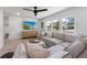 Bright living room with modern furniture, ceiling fan, and large windows offering natural light at 414 79Th St, Holmes Beach, FL 34217