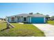Welcoming home with a spacious yard, nice landscaping and a modern turquoise garage door at 4404 5Th W Ave, Palmetto, FL 34221