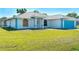 Inviting single-story home with a well-manicured lawn and bright blue garage door at 4404 5Th W Ave, Palmetto, FL 34221