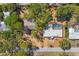 High-angle view of a property with swimming pool, mature trees, driveway, and road at 448 58Th St, Sarasota, FL 34243