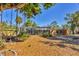 Spacious backyard with mature trees, a screened-in pool, and ample space for outdoor entertaining at 448 58Th St, Sarasota, FL 34243
