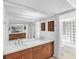 Bathroom featuring double sinks, warm wood cabinets, and a glass block shower at 448 58Th St, Sarasota, FL 34243