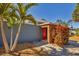 Modern home with a vibrant red front door, wooden accents, and lush landscaping at 448 58Th St, Sarasota, FL 34243