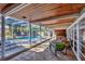 A covered pool area with stylish seating, brick pavers, and access to the pool and jacuzzi at 448 58Th St, Sarasota, FL 34243