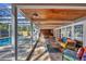 A covered pool area with stylish seating, brick pavers, and access to the pool and jacuzzi at 448 58Th St, Sarasota, FL 34243